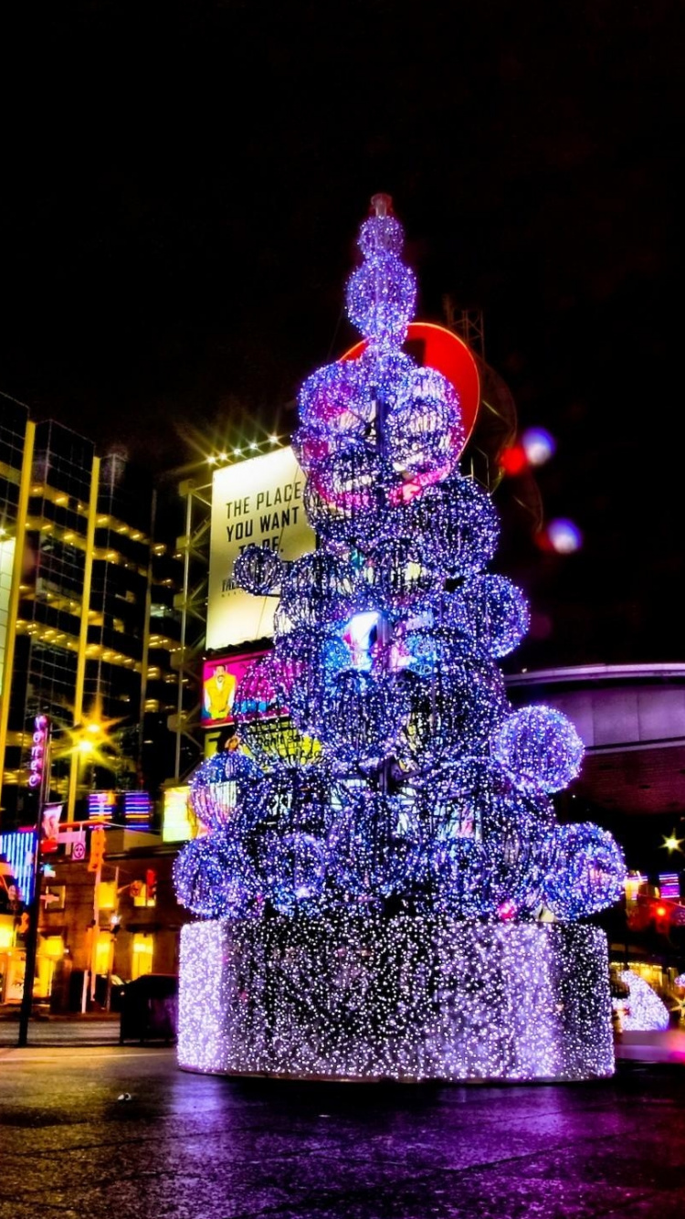Arbre de Noël Vert et Rouge Avec Guirlandes Lumineuses Pendant la Nuit. Wallpaper in 750x1334 Resolution
