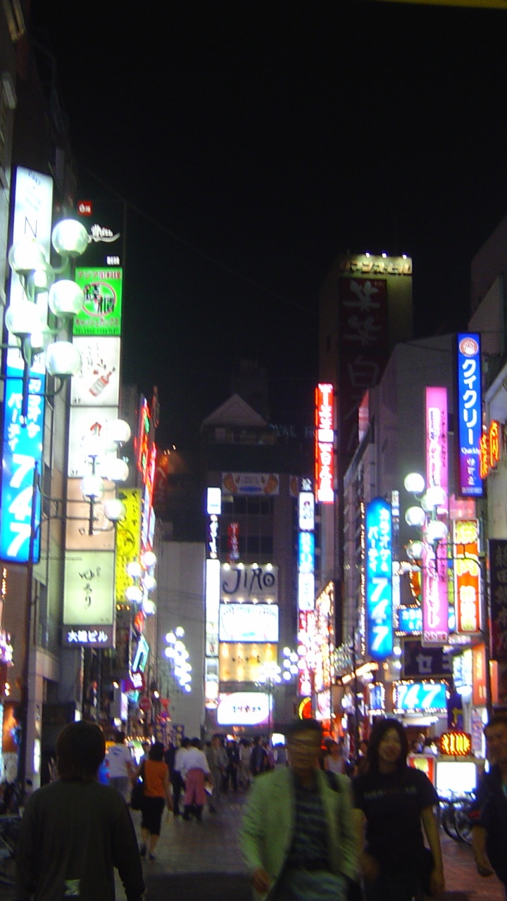 Personnes Marchant Dans la Rue Pendant la Nuit. Wallpaper in 720x1280 Resolution