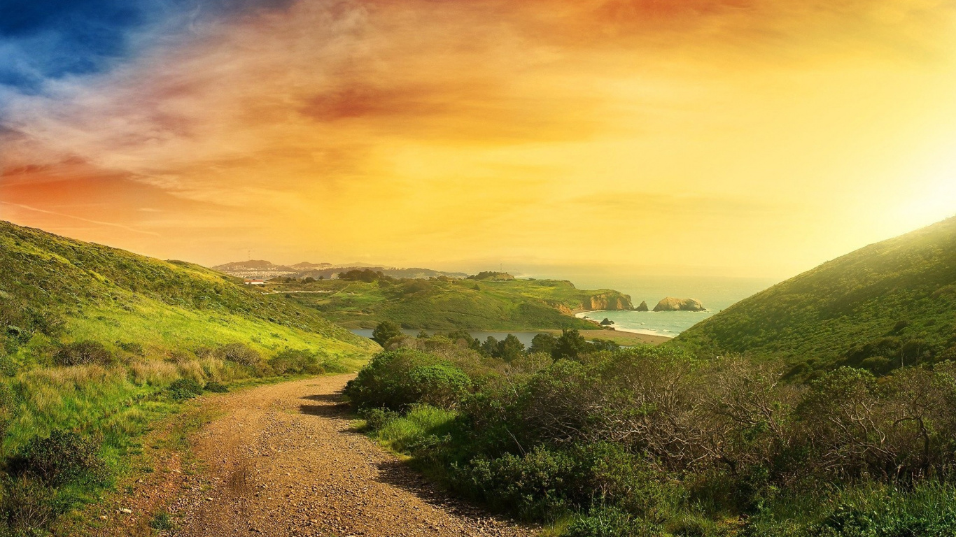 Green Grass Field Under Orange and Blue Sky. Wallpaper in 1366x768 Resolution