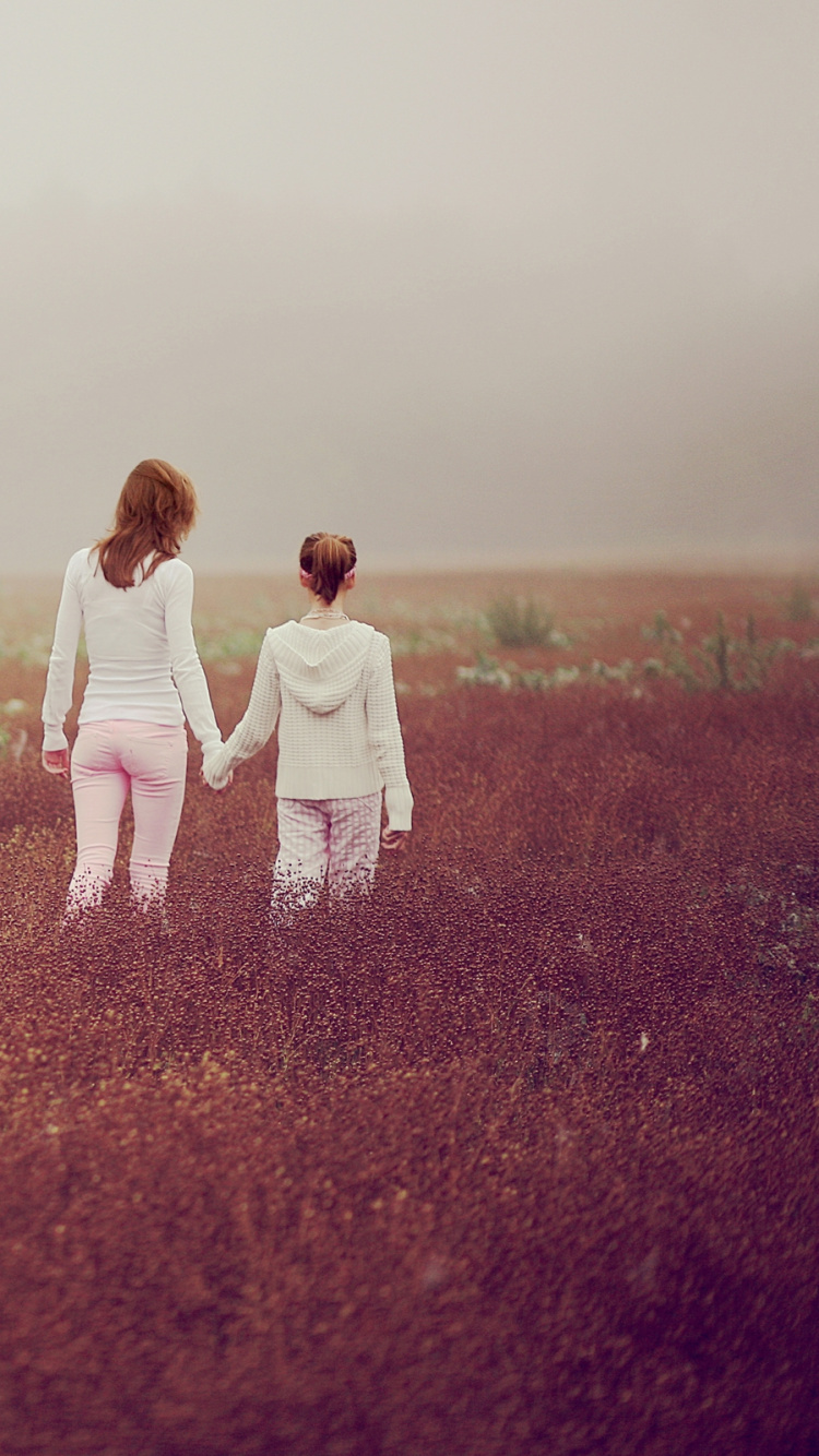 Man and Woman Walking on Red Grass Field During Daytime. Wallpaper in 750x1334 Resolution