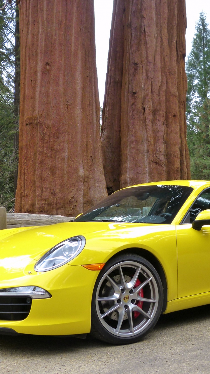 Porsche 911 Amarillo Estacionado Cerca de un Poste de Madera Marrón. Wallpaper in 720x1280 Resolution