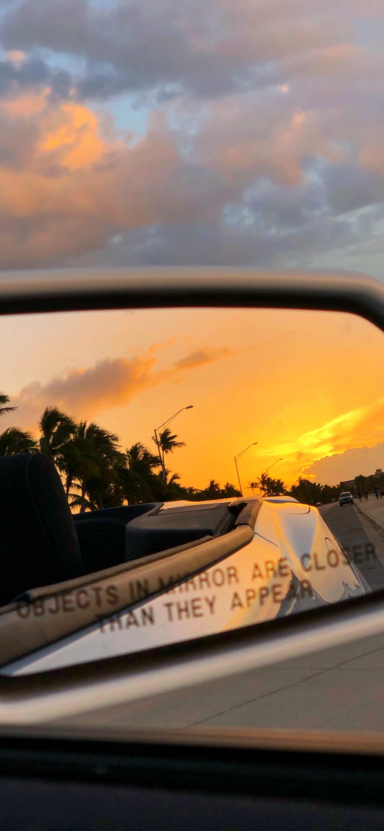 Car Side Mirror Showing White Car on Road During Sunset. Wallpaper in 1242x2688 Resolution
