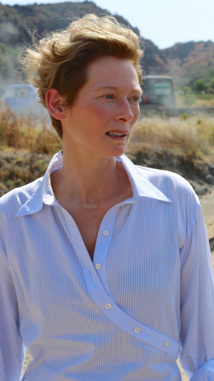 Woman in White Button up Shirt Standing on Brown Sand During Daytime. Wallpaper in 720x1280 Resolution