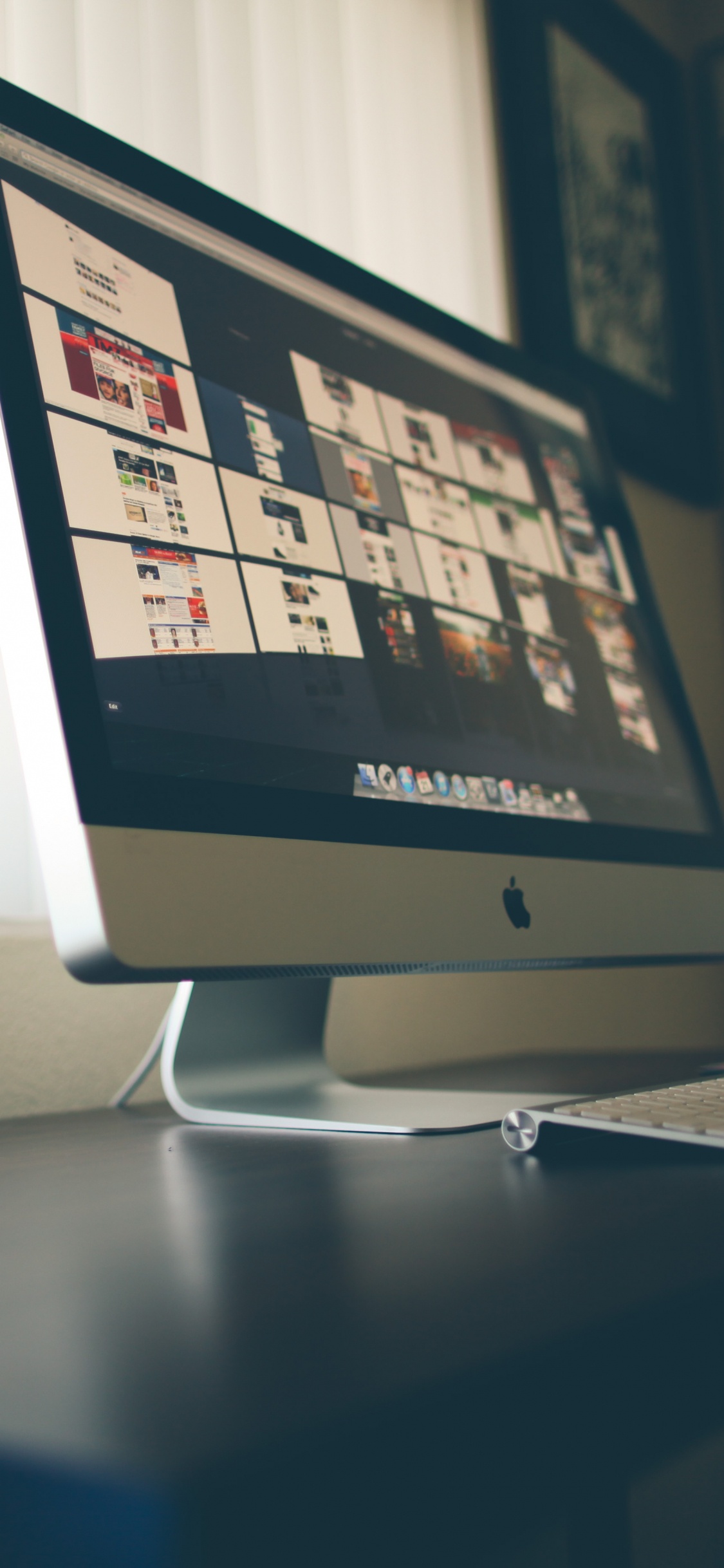 Imac Argenté Sur Table Près du Clavier Magique Apple. Wallpaper in 1125x2436 Resolution