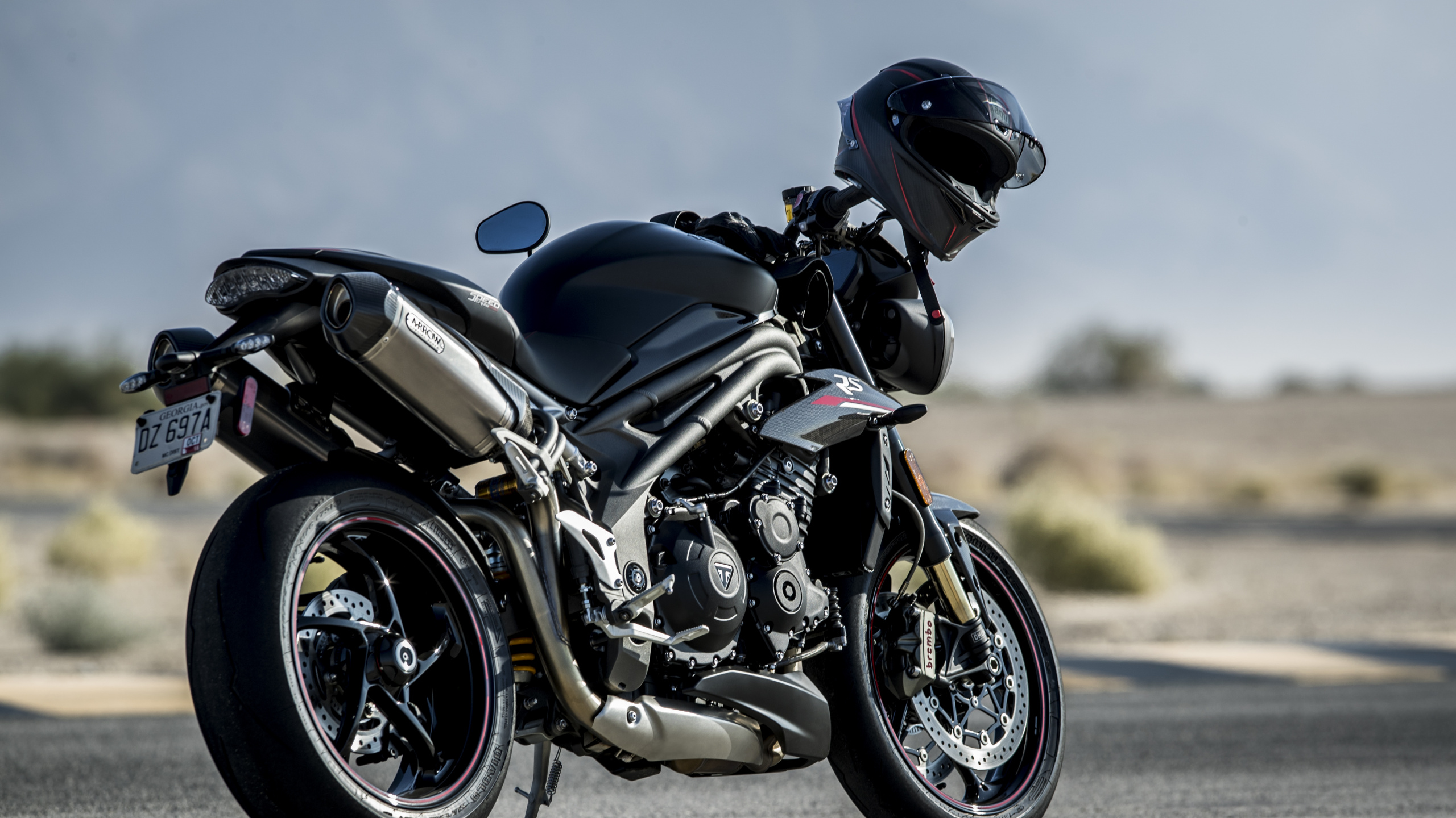 Mann Mit Schwarzem Helm, Der Ein Schwarzes Sportrad Fährt Riding. Wallpaper in 2560x1440 Resolution