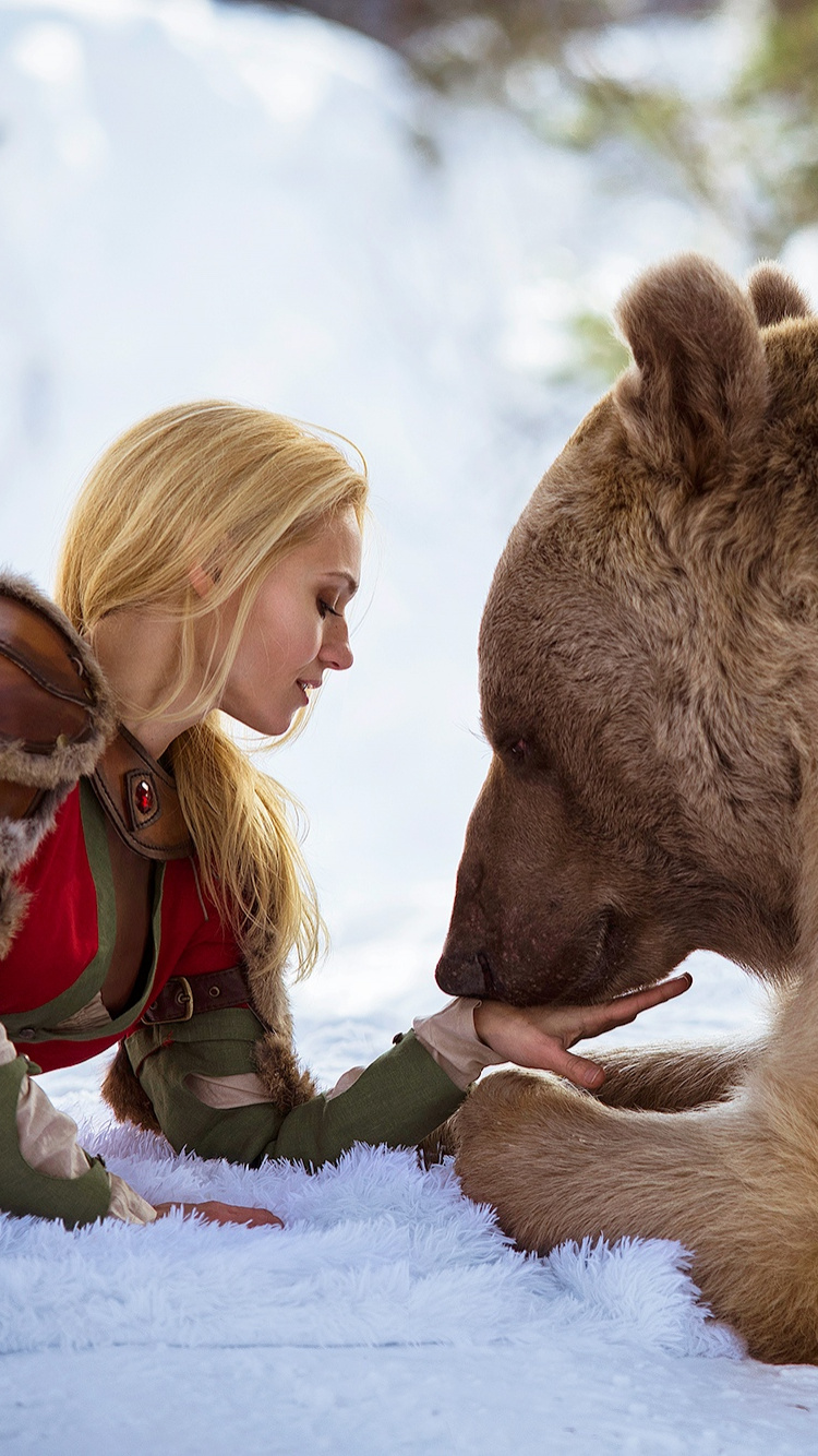 Girl in Red Jacket Beside Brown Bear on Snow Covered Ground During Daytime. Wallpaper in 750x1334 Resolution