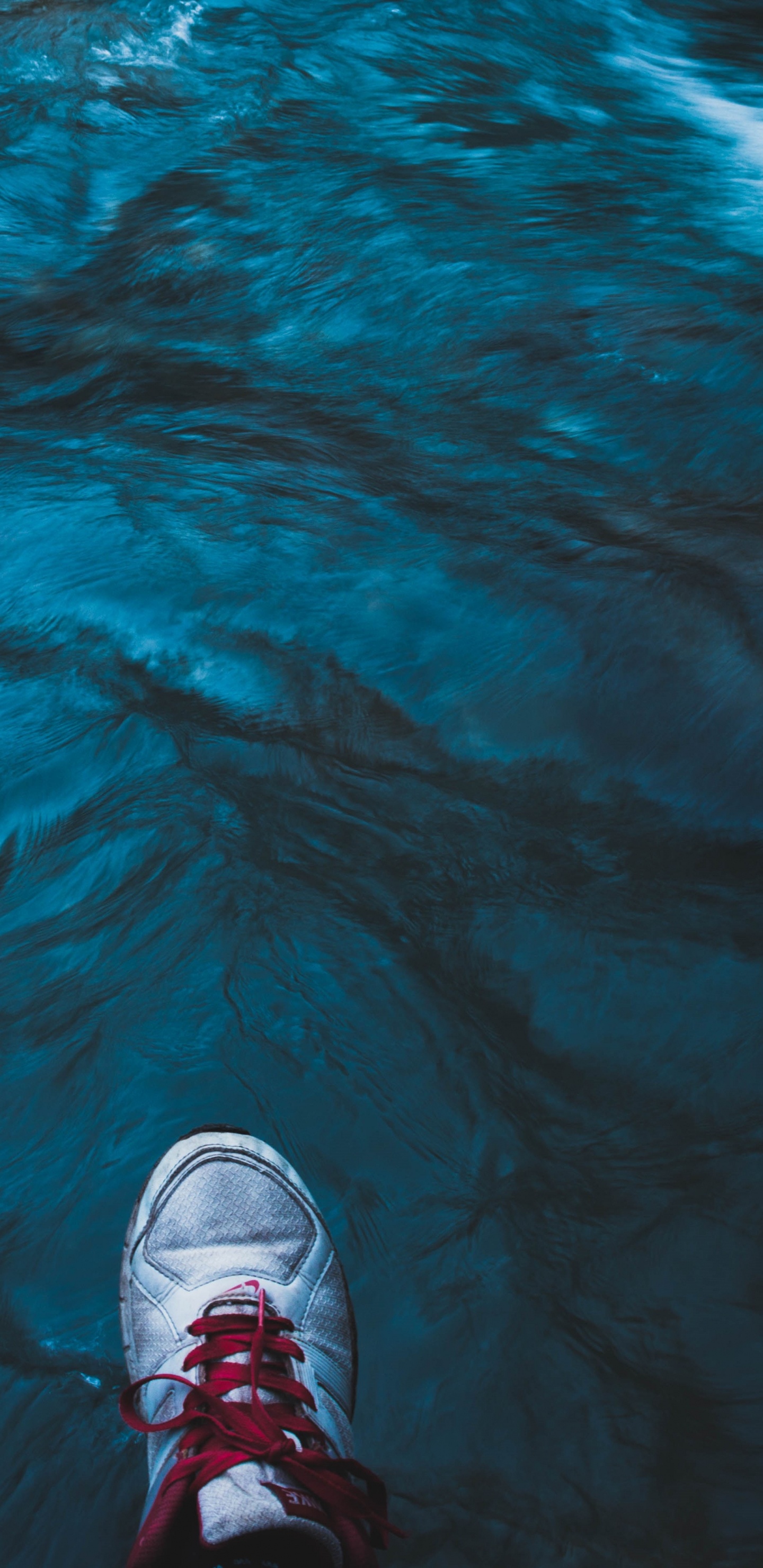 Person in Schwarz-weißen Turnschuhen, Die Auf Dem Wasser Steht. Wallpaper in 1440x2960 Resolution