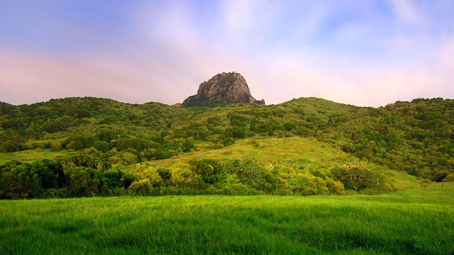 Green Grass Field Near Mountain Under Cloudy Sky During Daytime. Wallpaper in 1920x1080 Resolution