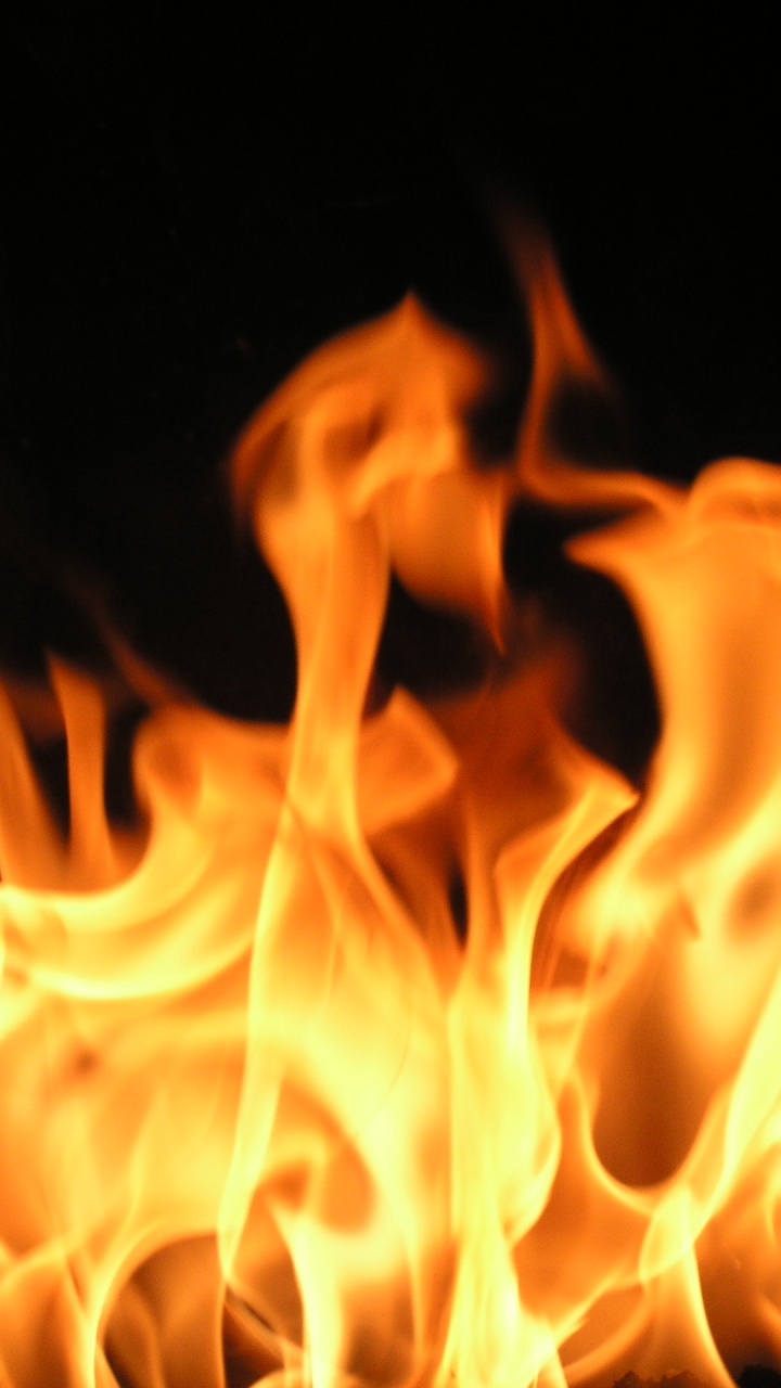 Orange Fire in Black Background. Wallpaper in 720x1280 Resolution