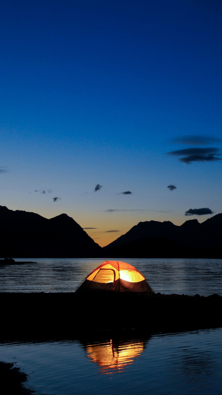 Silhouette de Montagne Près D'un Plan D'eau Pendant le Coucher du Soleil. Wallpaper in 750x1334 Resolution