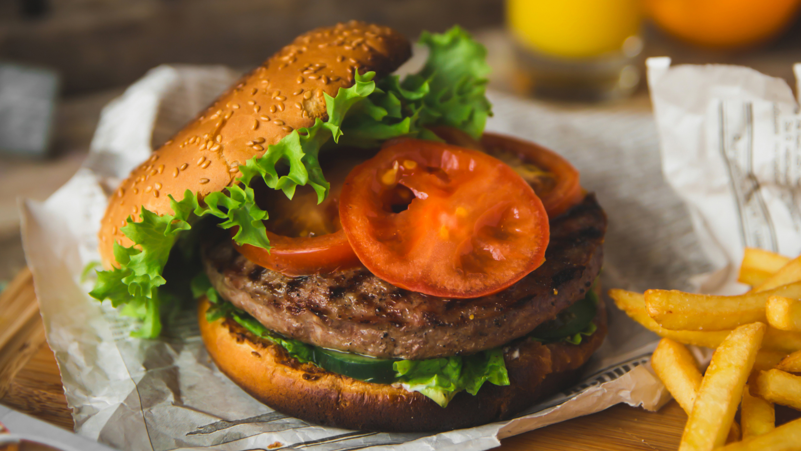 Burger Mit Salat Und Tomate Auf Weißem Papier. Wallpaper in 2560x1440 Resolution