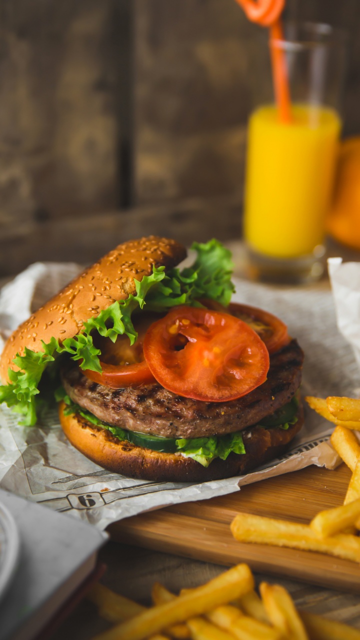 Burger Mit Salat Und Tomate Auf Weißem Papier. Wallpaper in 720x1280 Resolution