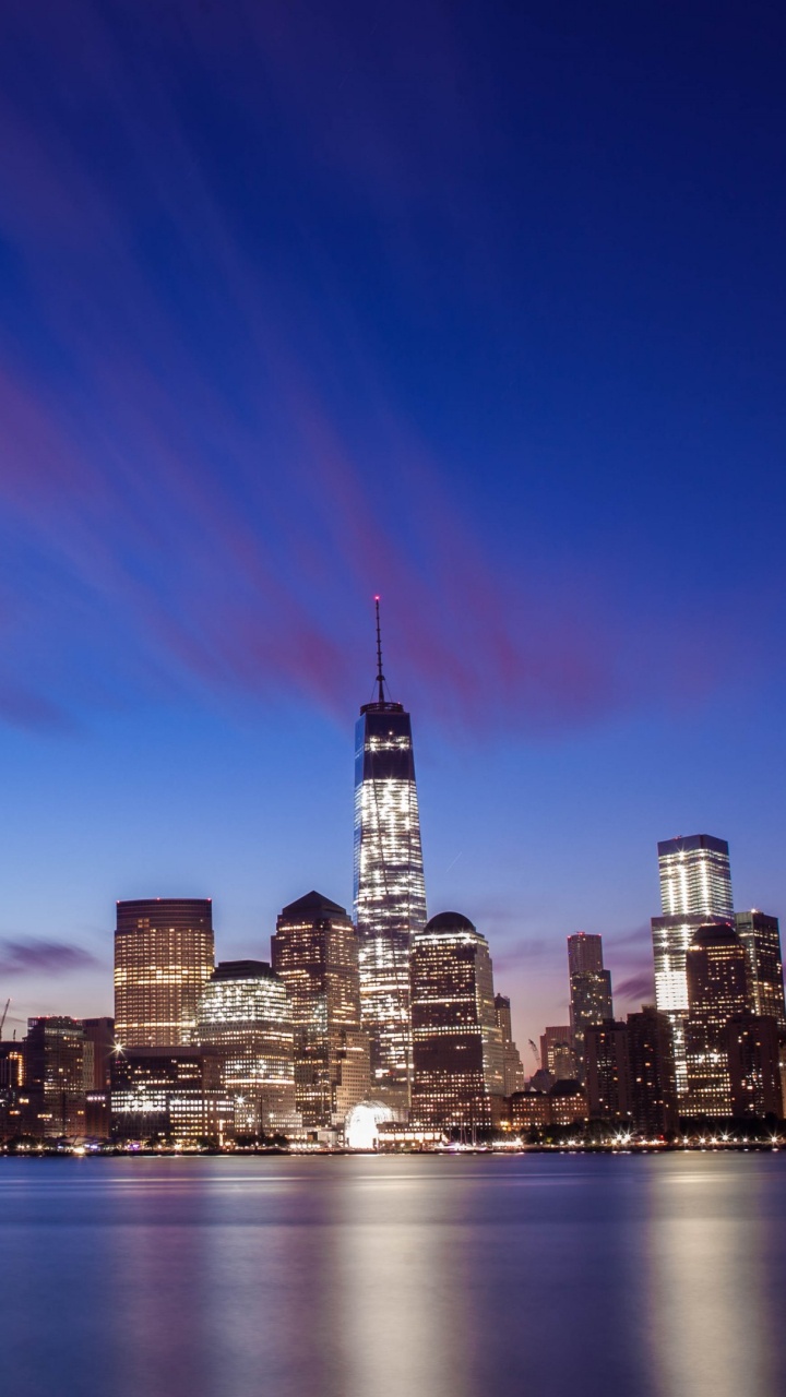 Horizonte de la Ciudad a Través Del Cuerpo de Agua Durante la Noche.. Wallpaper in 720x1280 Resolution
