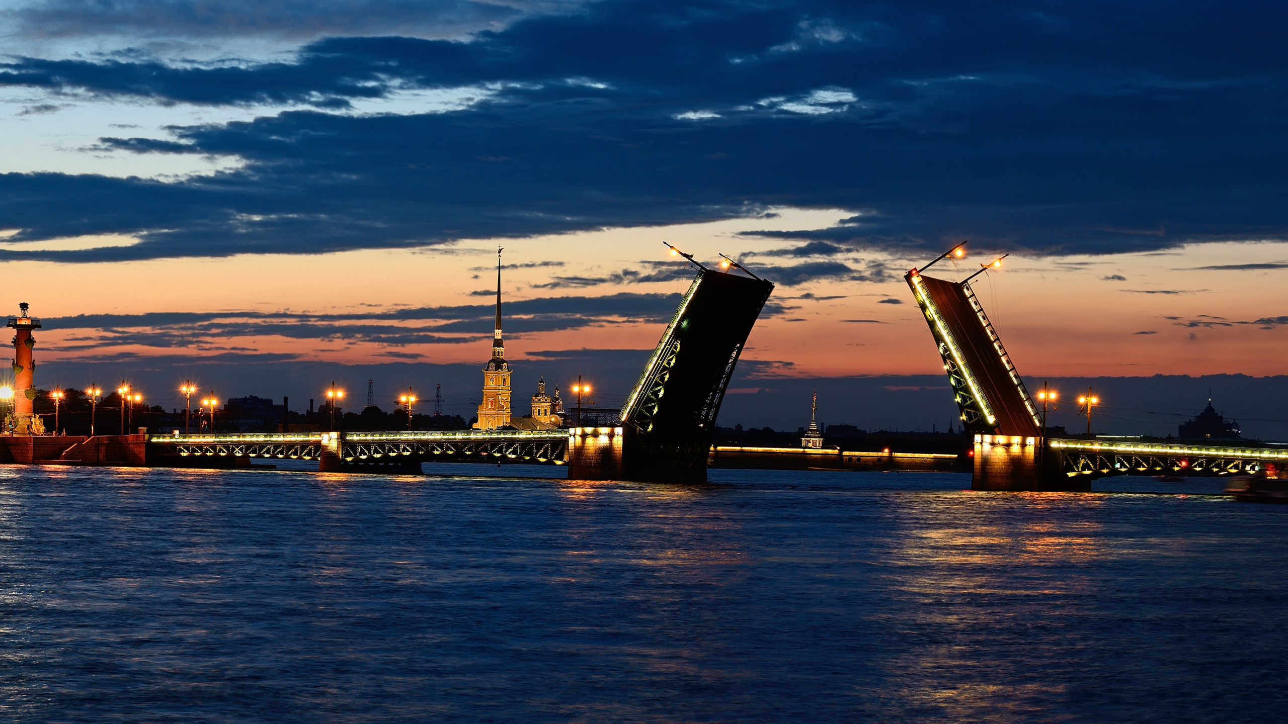 City Skyline Across Body of Water During Sunset. Wallpaper in 2560x1440 Resolution