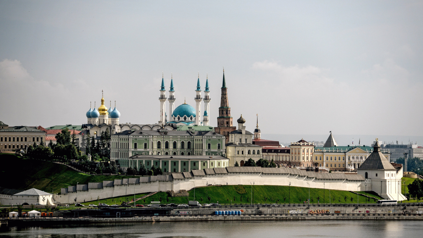 White and Green Concrete Building Near Body of Water During Daytime. Wallpaper in 1366x768 Resolution