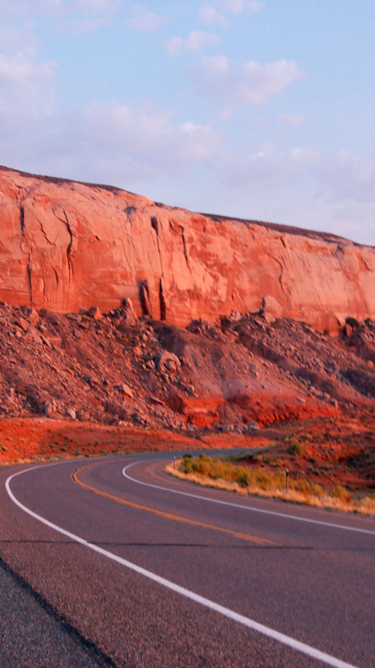 Braune Felsformation Neben Grauer Asphaltstraße Tagsüber. Wallpaper in 750x1334 Resolution