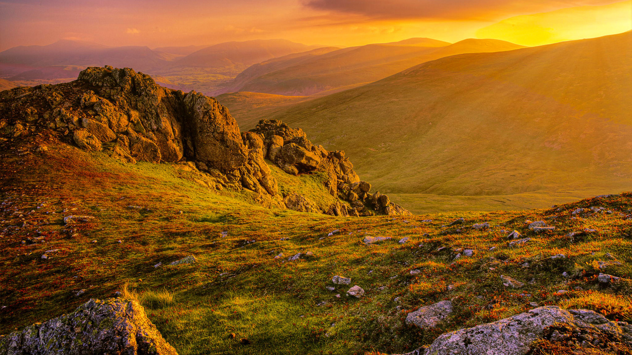 Green Grass Field Near Brown Mountain During Daytime. Wallpaper in 1280x720 Resolution