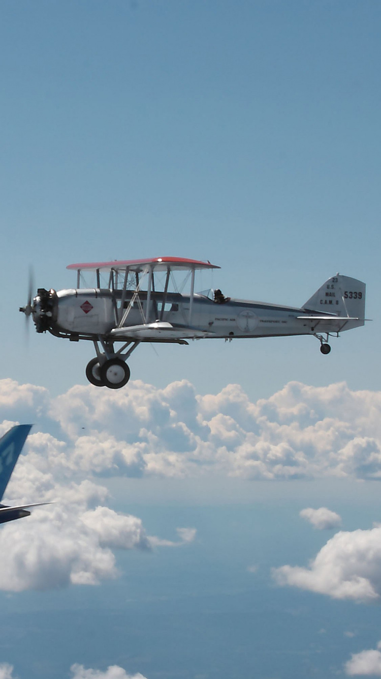 Blue and White Airplane Flying Under Blue Sky During Daytime. Wallpaper in 750x1334 Resolution