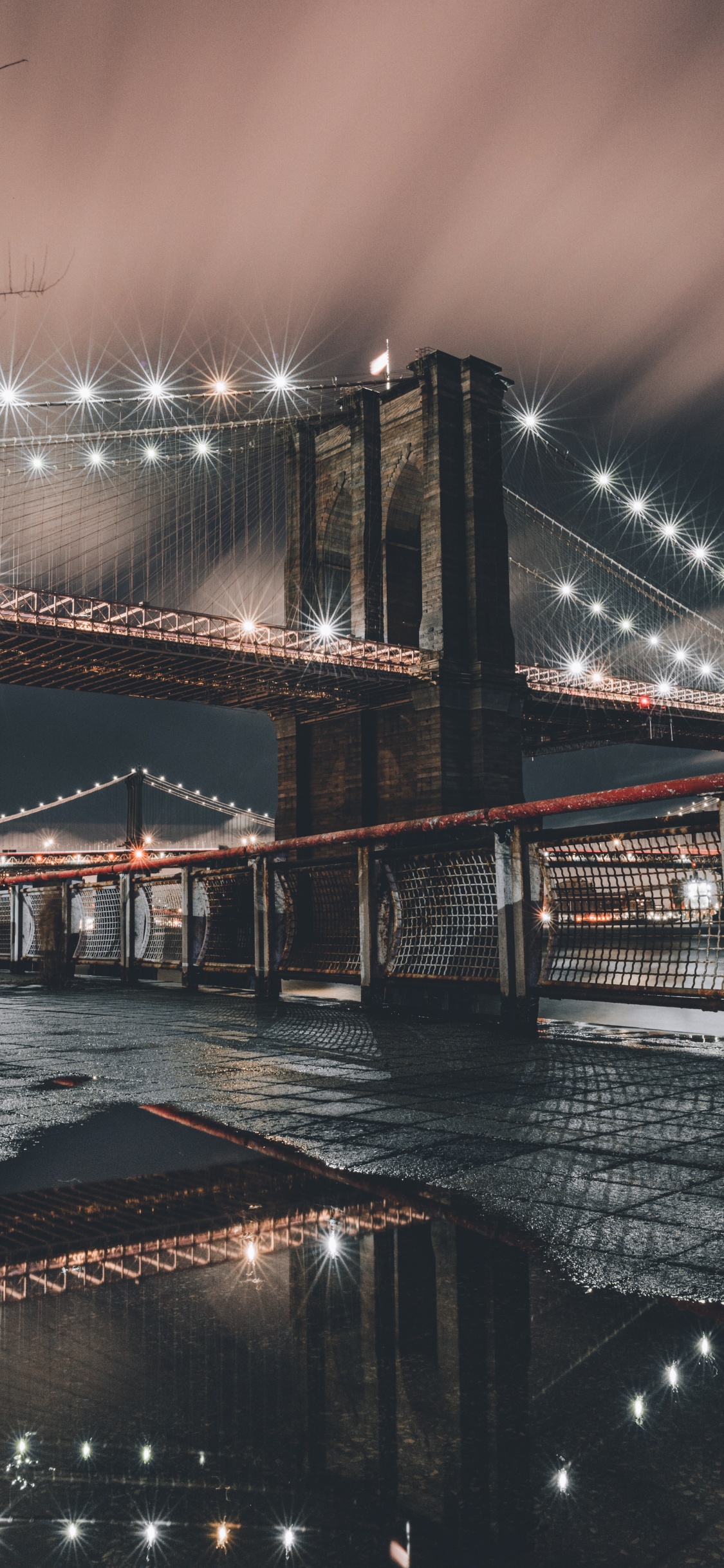 Brown Bridge Over Water During Night Time. Wallpaper in 1125x2436 Resolution
