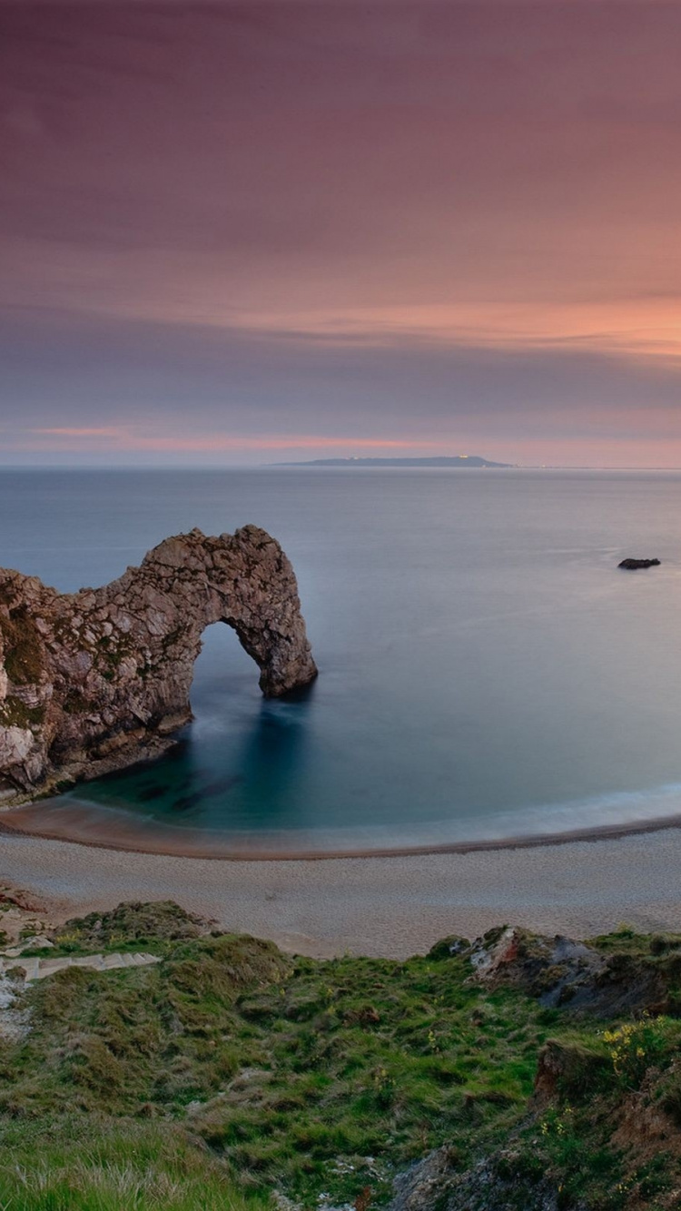 Formación de Roca Marrón en el Cuerpo de Agua Durante el Día.. Wallpaper in 750x1334 Resolution