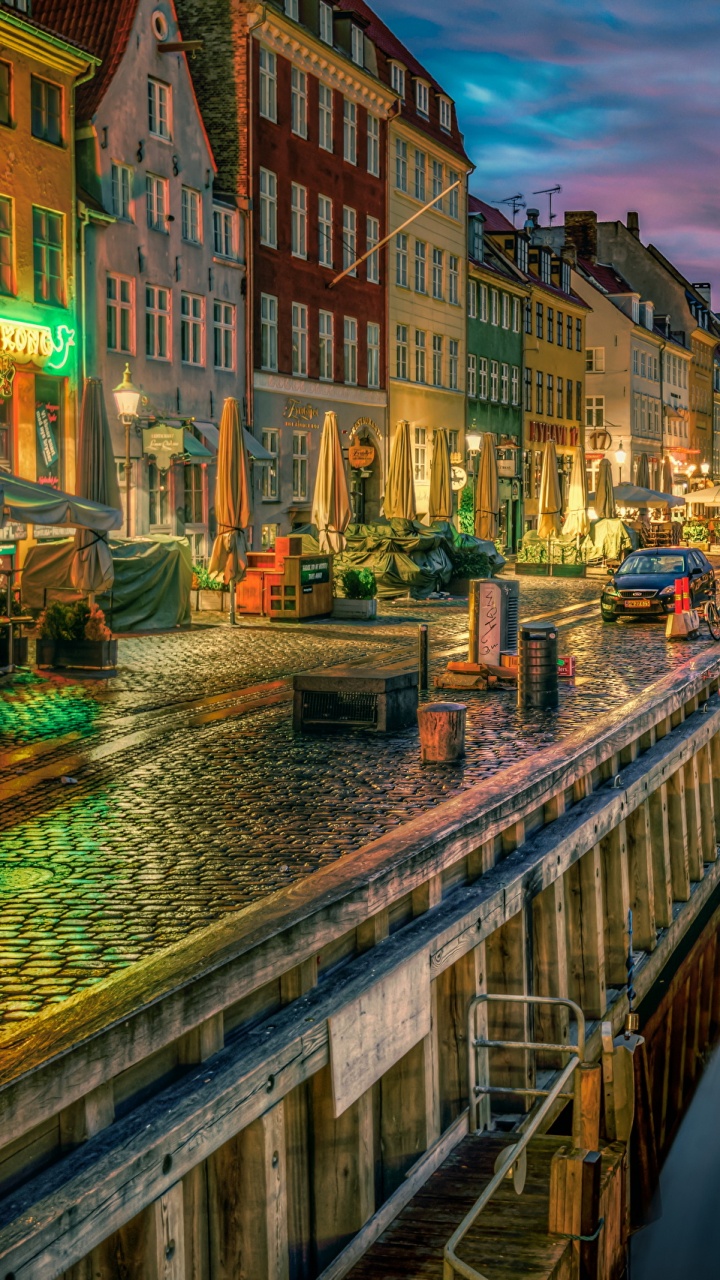 Braunes Und Weißes Betongebäude in Der Nähe Des Flusses Während Der Nacht. Wallpaper in 720x1280 Resolution