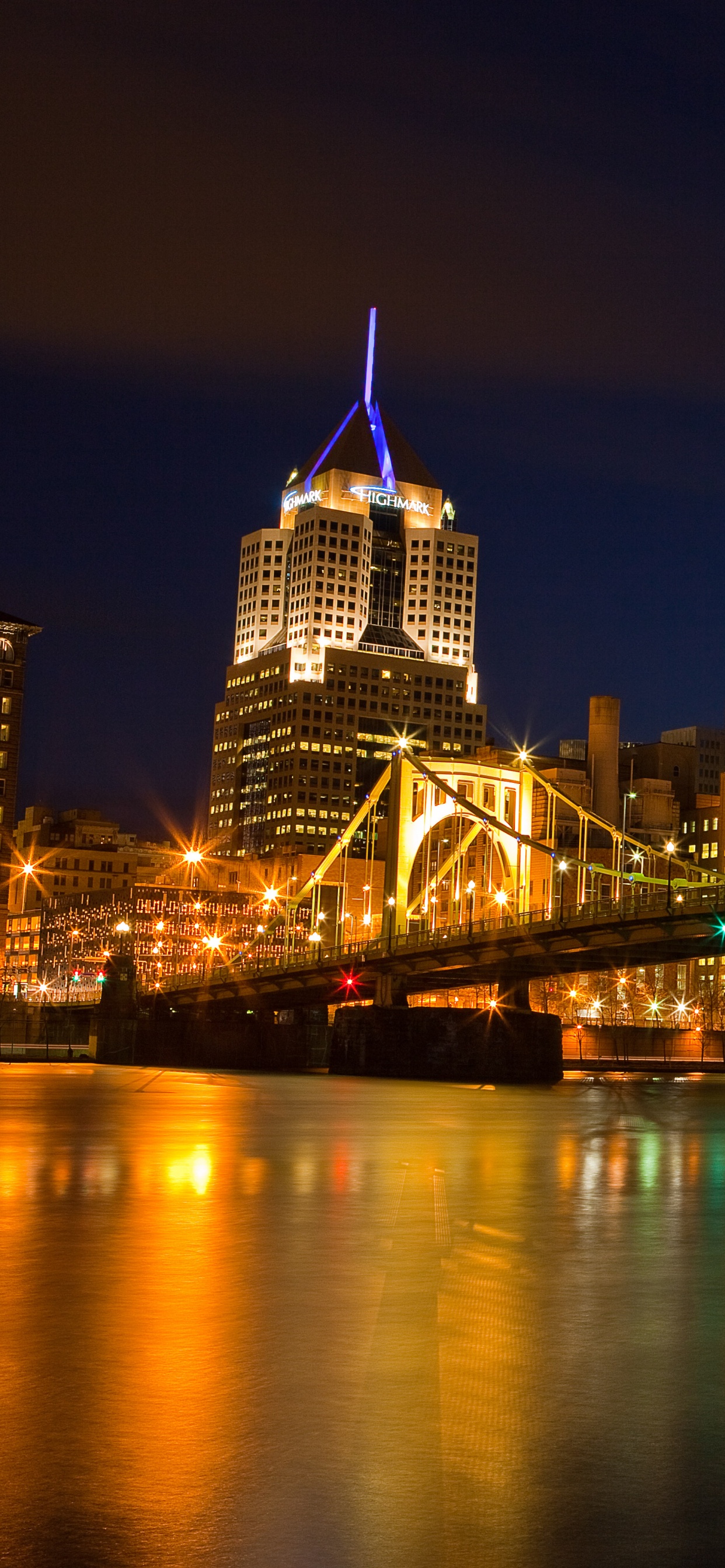 Lighted Bridge Over Water During Night Time. Wallpaper in 1242x2688 Resolution