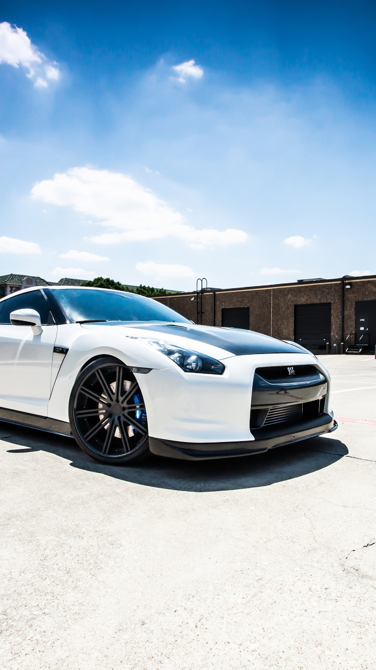 White Coupe Parked on Gray Concrete Floor During Daytime. Wallpaper in 750x1334 Resolution