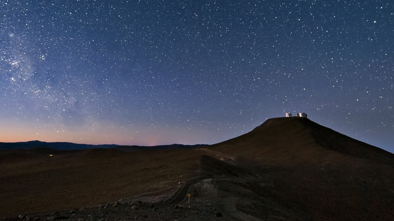 Brauner Berg Unter Blauem Himmel Mit Sternen Während Der Nacht. Wallpaper in 1366x768 Resolution