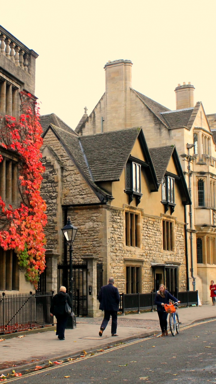 Leute, Die Tagsüber Auf Dem Bürgersteig in Der Nähe Eines Braunen Betongebäudes Gehen. Wallpaper in 720x1280 Resolution