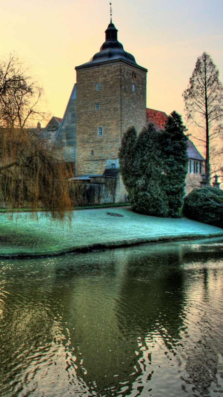 Edificio de Hormigón Marrón Cerca Del Río Durante el Día. Wallpaper in 750x1334 Resolution