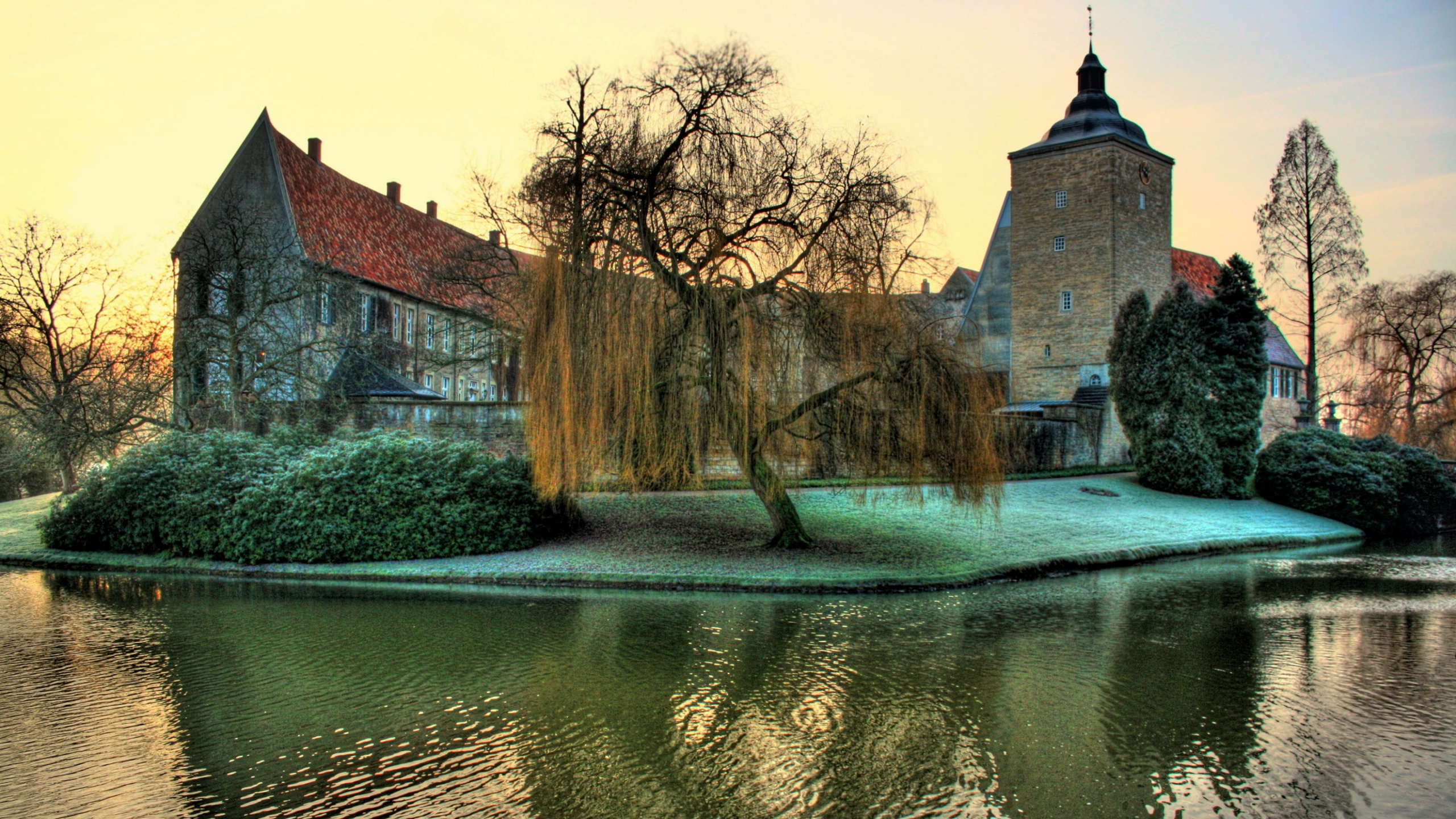 Braunes Betongebäude in Der Nähe Des Flusses Tagsüber. Wallpaper in 2560x1440 Resolution