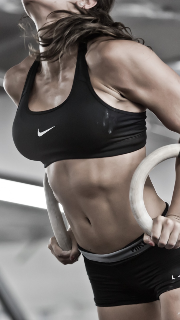 Femme en Soutien-gorge de Sport Noir et Short Noir Tenant Une Barre en Acier Blanc. Wallpaper in 720x1280 Resolution