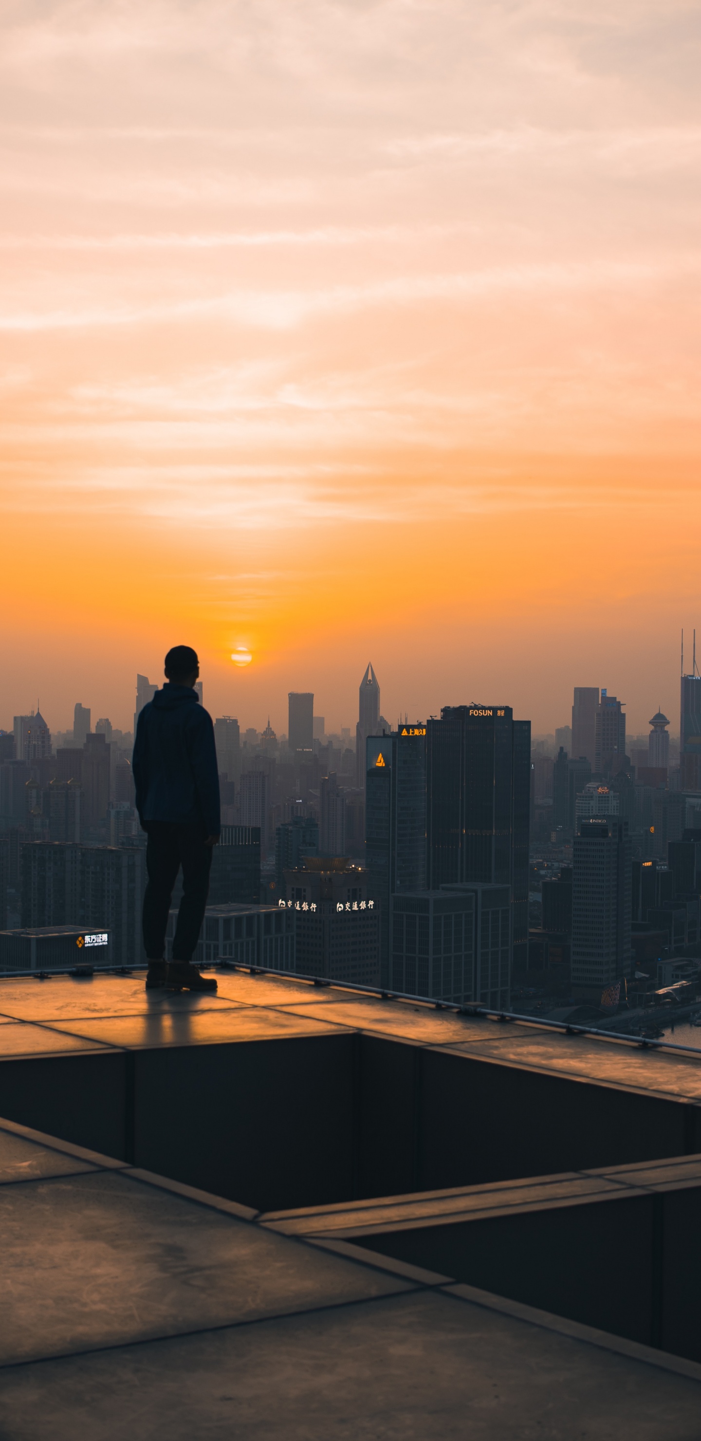 Hombre de Chaqueta Negra de Pie en la Parte Superior Del Edificio Durante la Puesta de Sol. Wallpaper in 1440x2960 Resolution