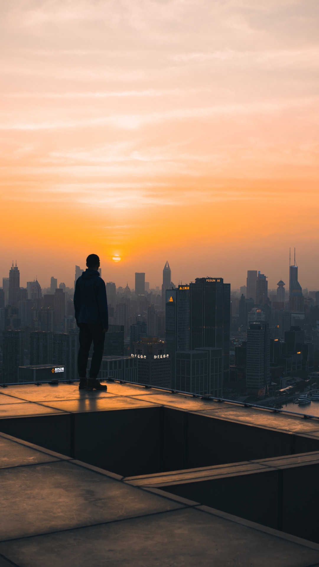 L'homme en Veste Noire Debout au Sommet du Bâtiment Pendant le Coucher du Soleil. Wallpaper in 1080x1920 Resolution