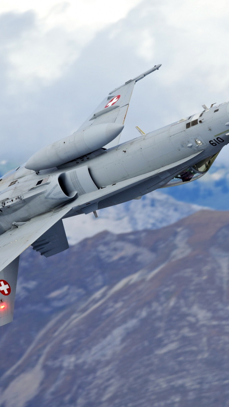 Grauer Kampfjet, Der Tagsüber Über Den Berg Fliegt. Wallpaper in 750x1334 Resolution