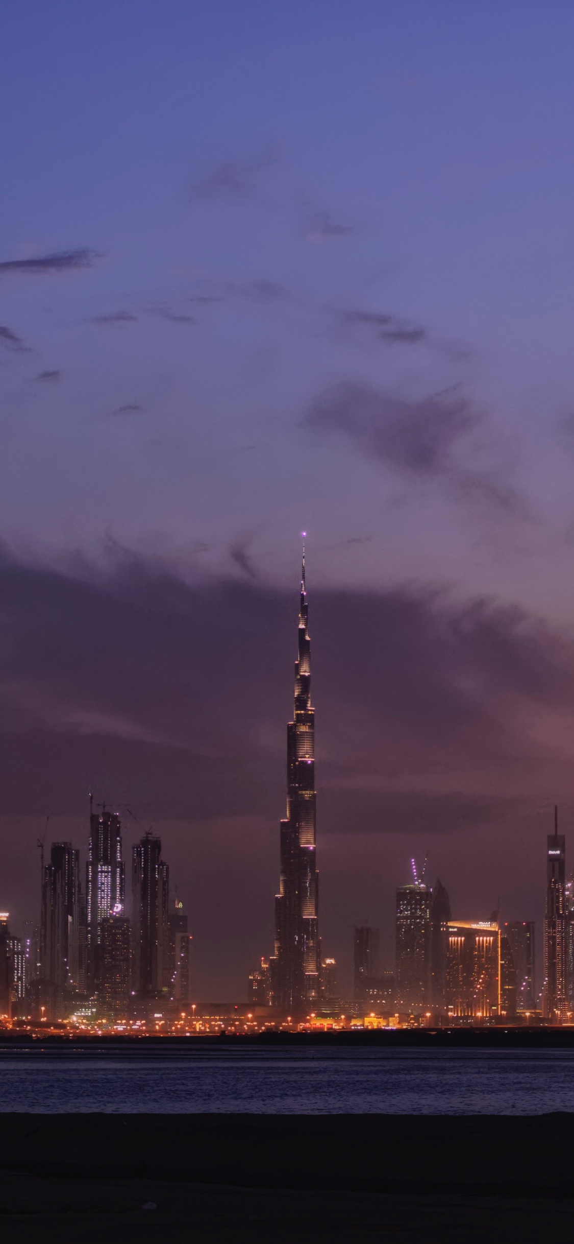 City Skyline During Night Time. Wallpaper in 1125x2436 Resolution