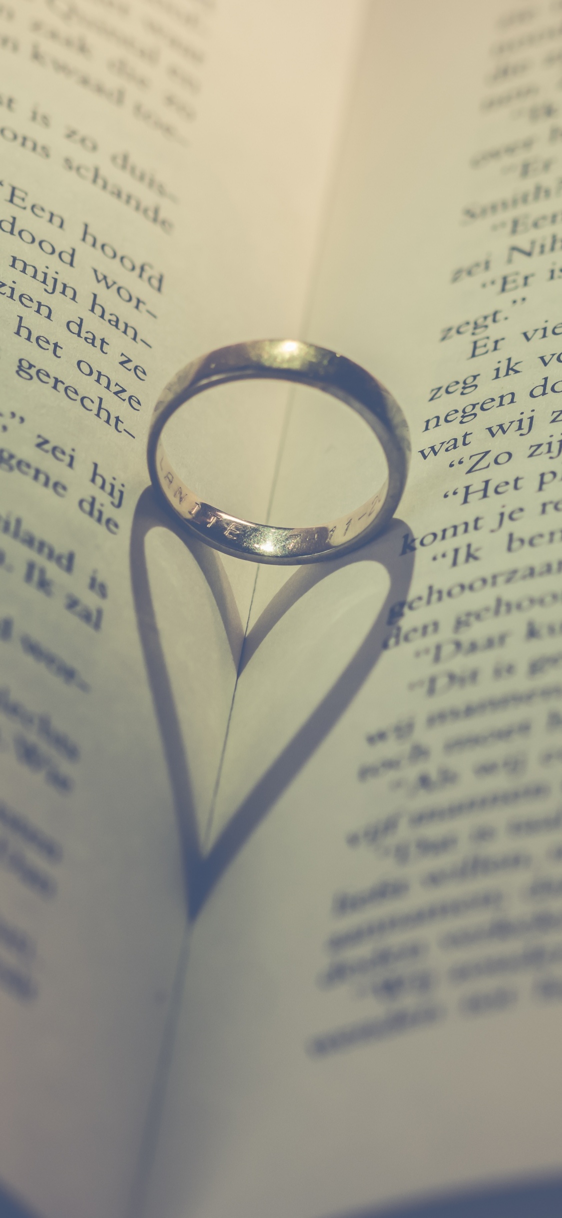 Silver Ring on Book Page. Wallpaper in 1125x2436 Resolution