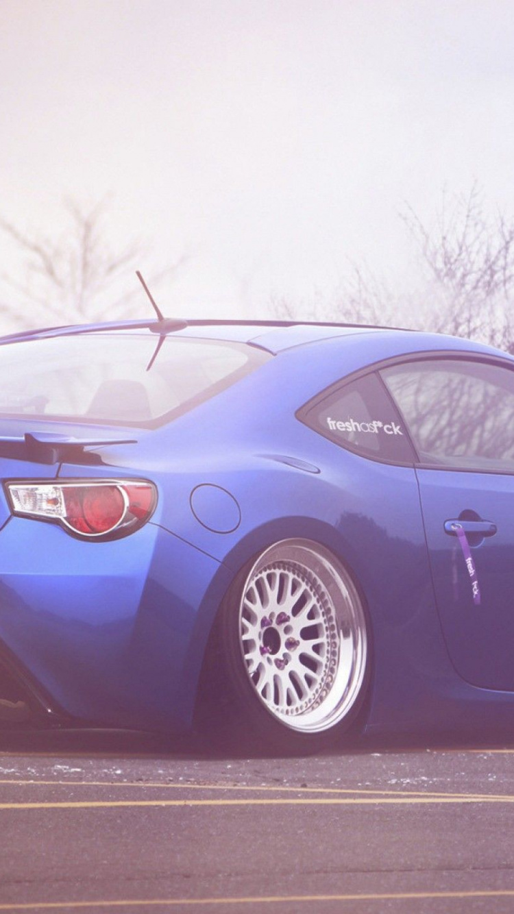 Schwarzer Porsche 911 Auf Schneebedecktem Boden. Wallpaper in 750x1334 Resolution