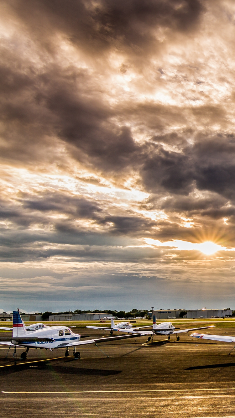 White and Black Plane on Gray Asphalt Road Under Gray Cloudy Sky During Daytime. Wallpaper in 750x1334 Resolution