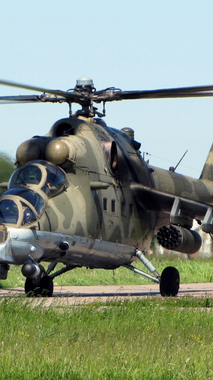 Green and Black Camouflage Military Helicopter on Green Grass Field During Daytime. Wallpaper in 750x1334 Resolution