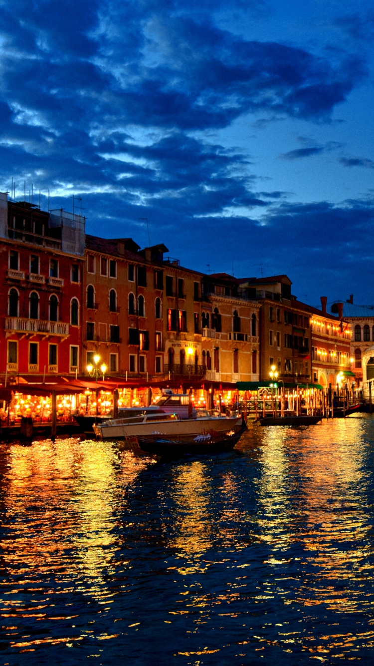 Edificio de Hormigón Marrón Junto al Río Bajo un Cielo Azul Durante el Día. Wallpaper in 750x1334 Resolution