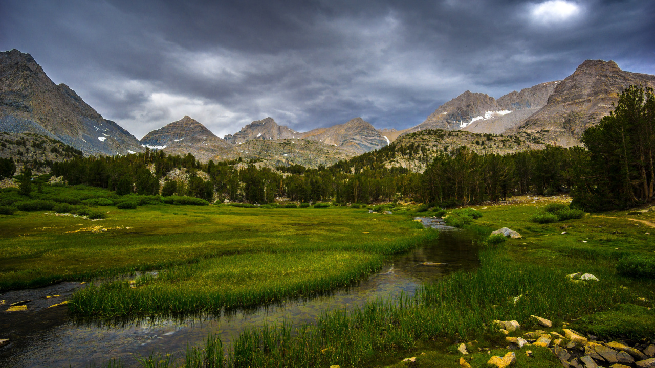 Green Grass Field Near Mountain Under Cloudy Sky During Daytime. Wallpaper in 1280x720 Resolution