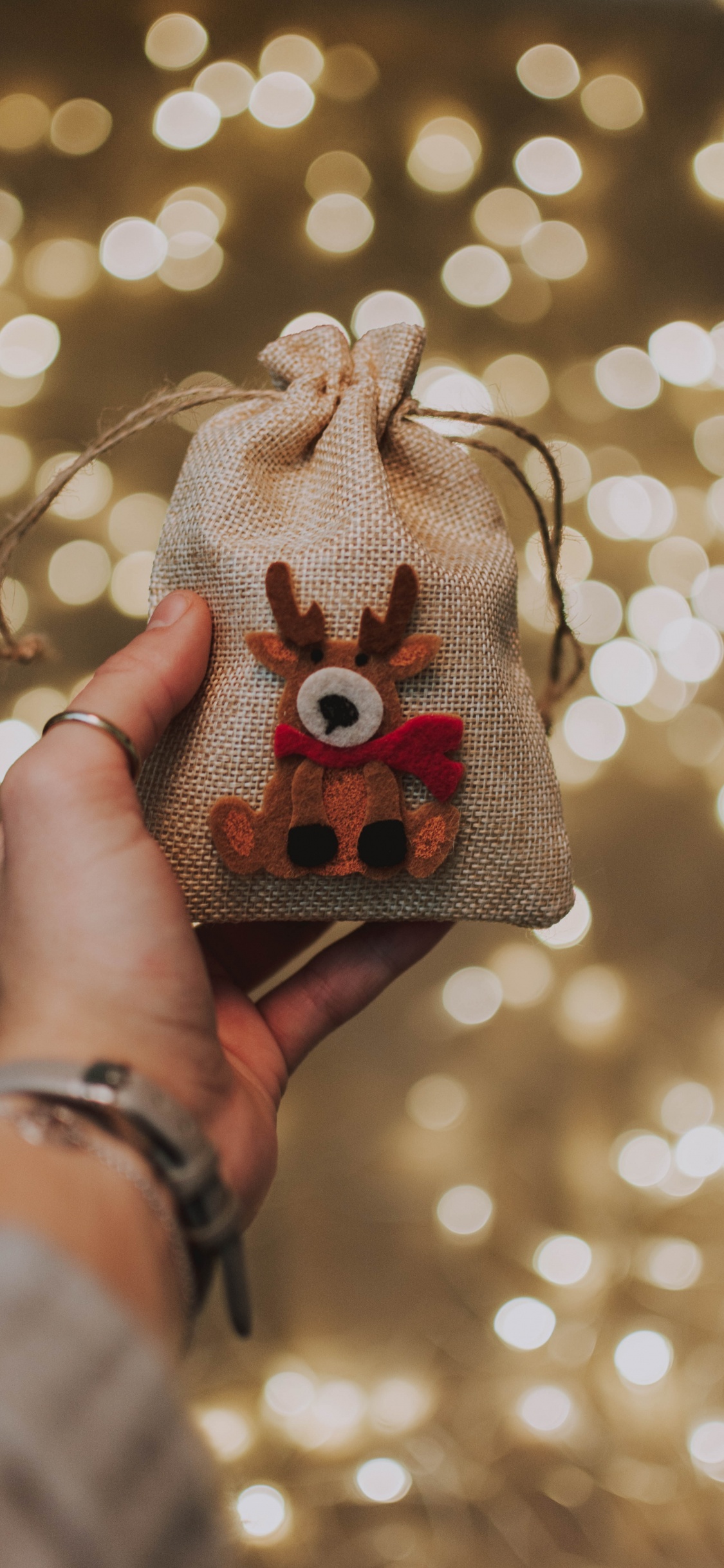 Person Holding Gray and Red Knit Cap. Wallpaper in 1125x2436 Resolution
