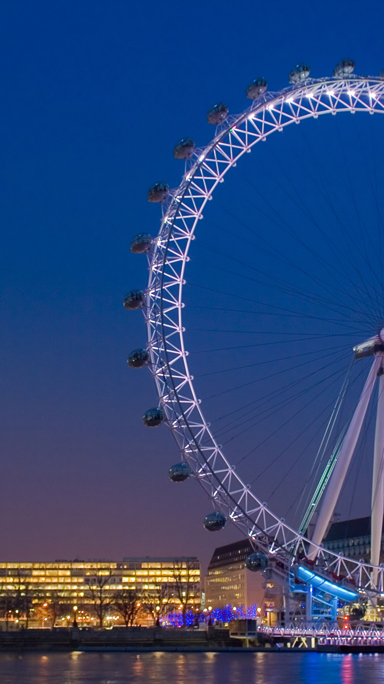 Noria Cerca de Los Edificios de la Ciudad Durante la Noche. Wallpaper in 750x1334 Resolution