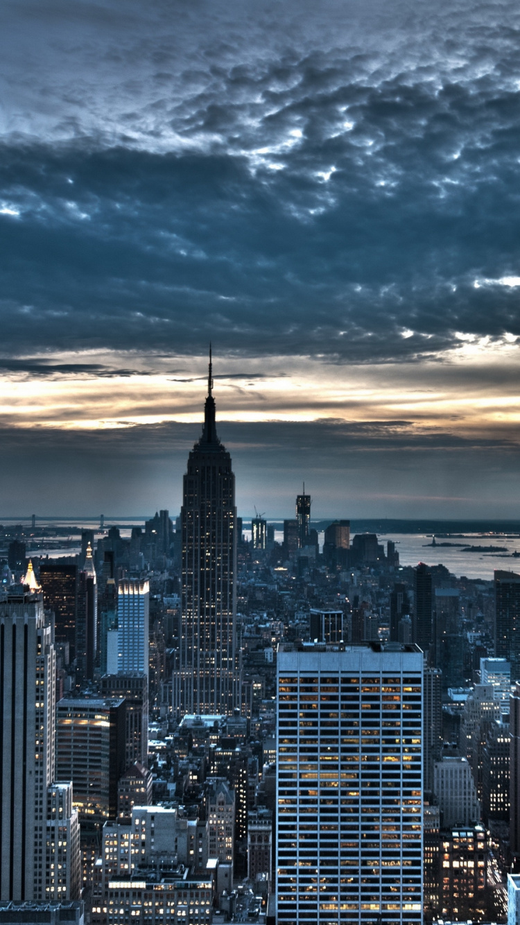 City Skyline Under Cloudy Sky During Night Time. Wallpaper in 750x1334 Resolution