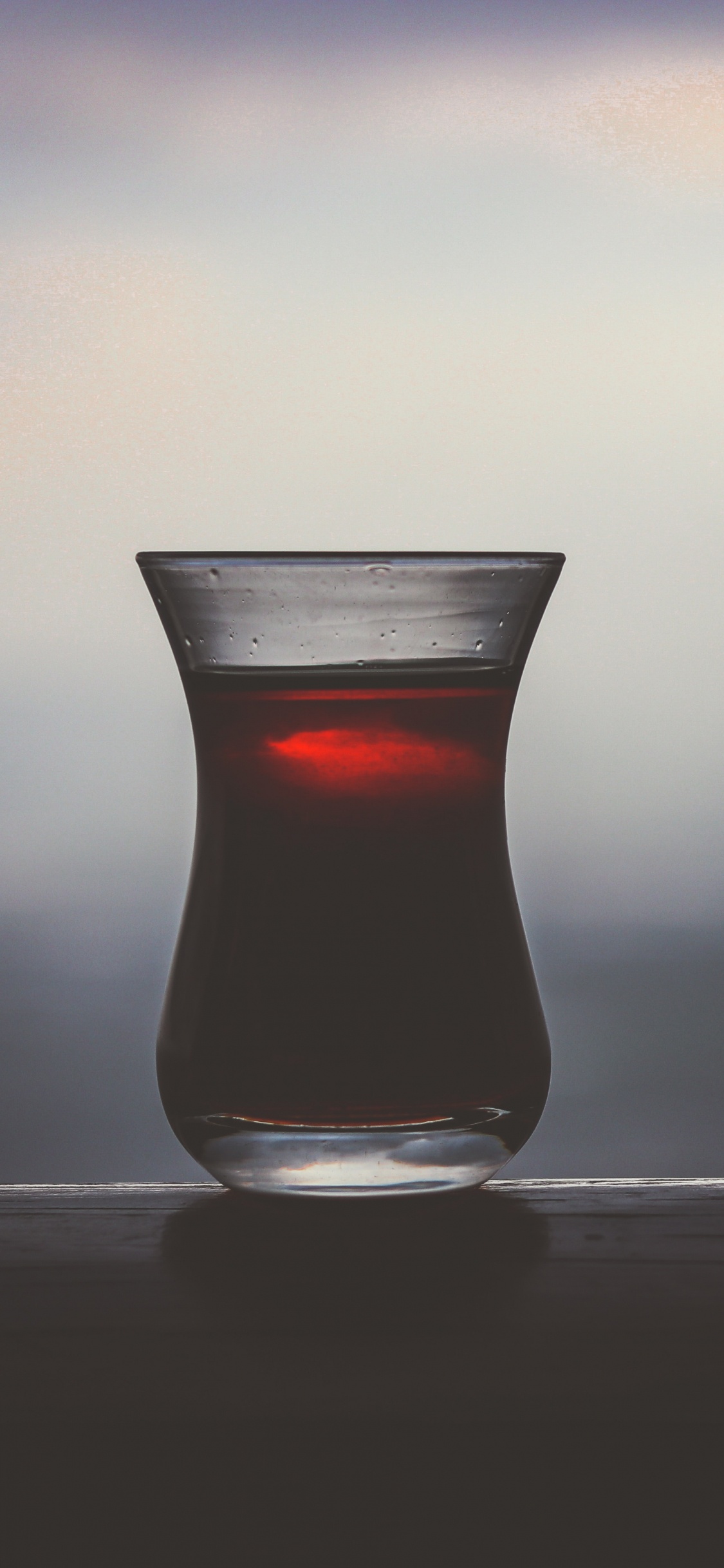 Clear Shot Glass With Red Liquid. Wallpaper in 1125x2436 Resolution