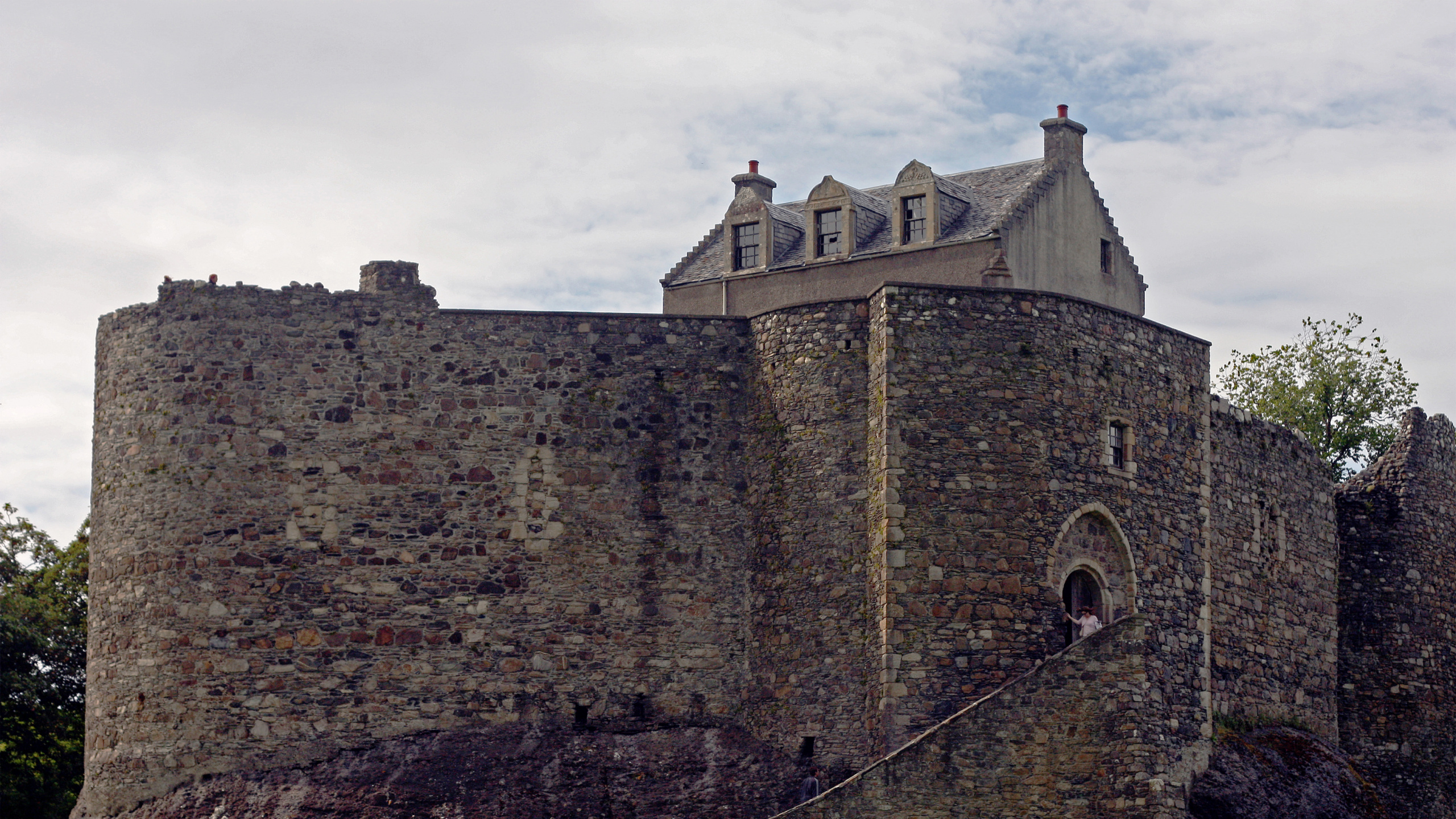 Braunes Backsteingebäude Auf Grüner Wiese Unter Weißen Wolken Tagsüber. Wallpaper in 2560x1440 Resolution