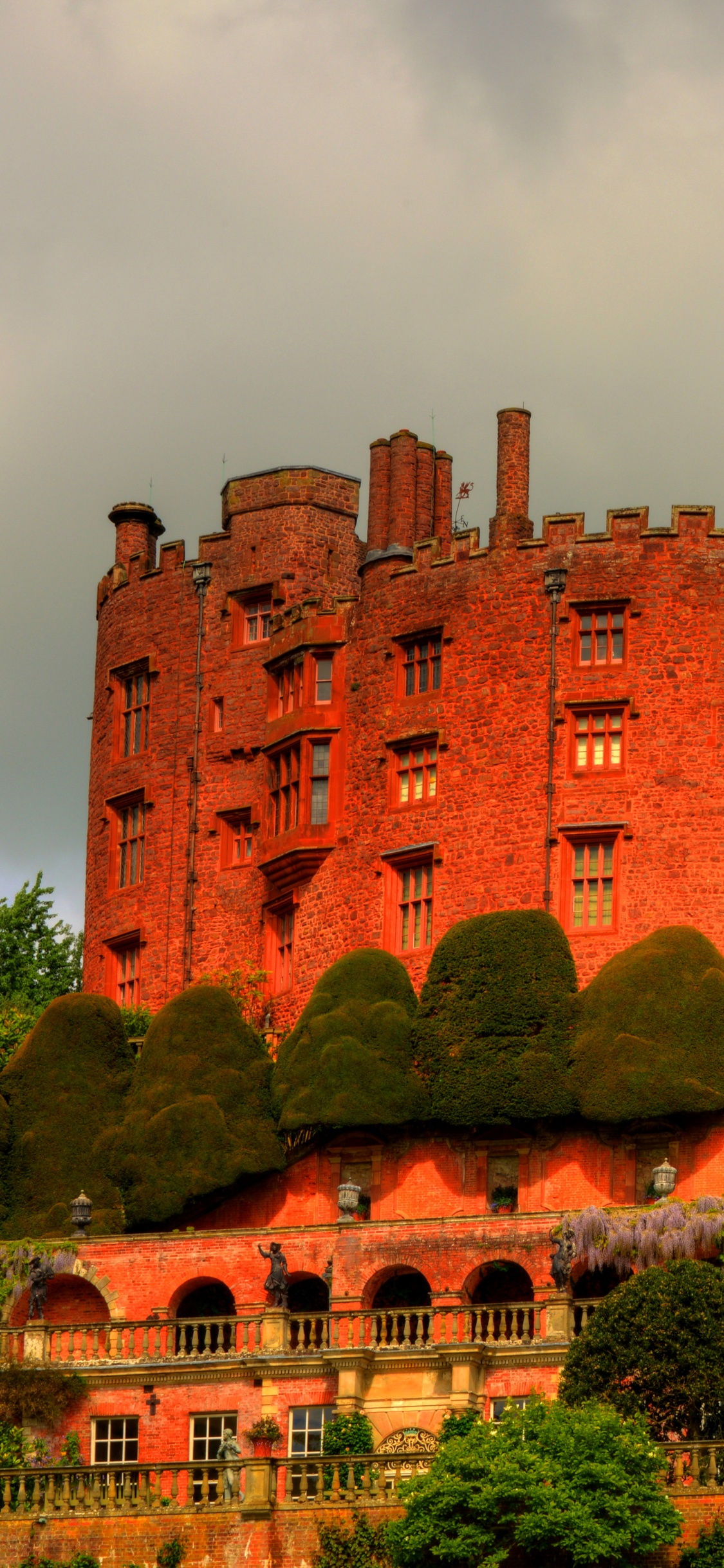 Bâtiment en Béton Brun Près D'arbres Verts Sous Des Nuages Blancs Pendant la Journée. Wallpaper in 1125x2436 Resolution