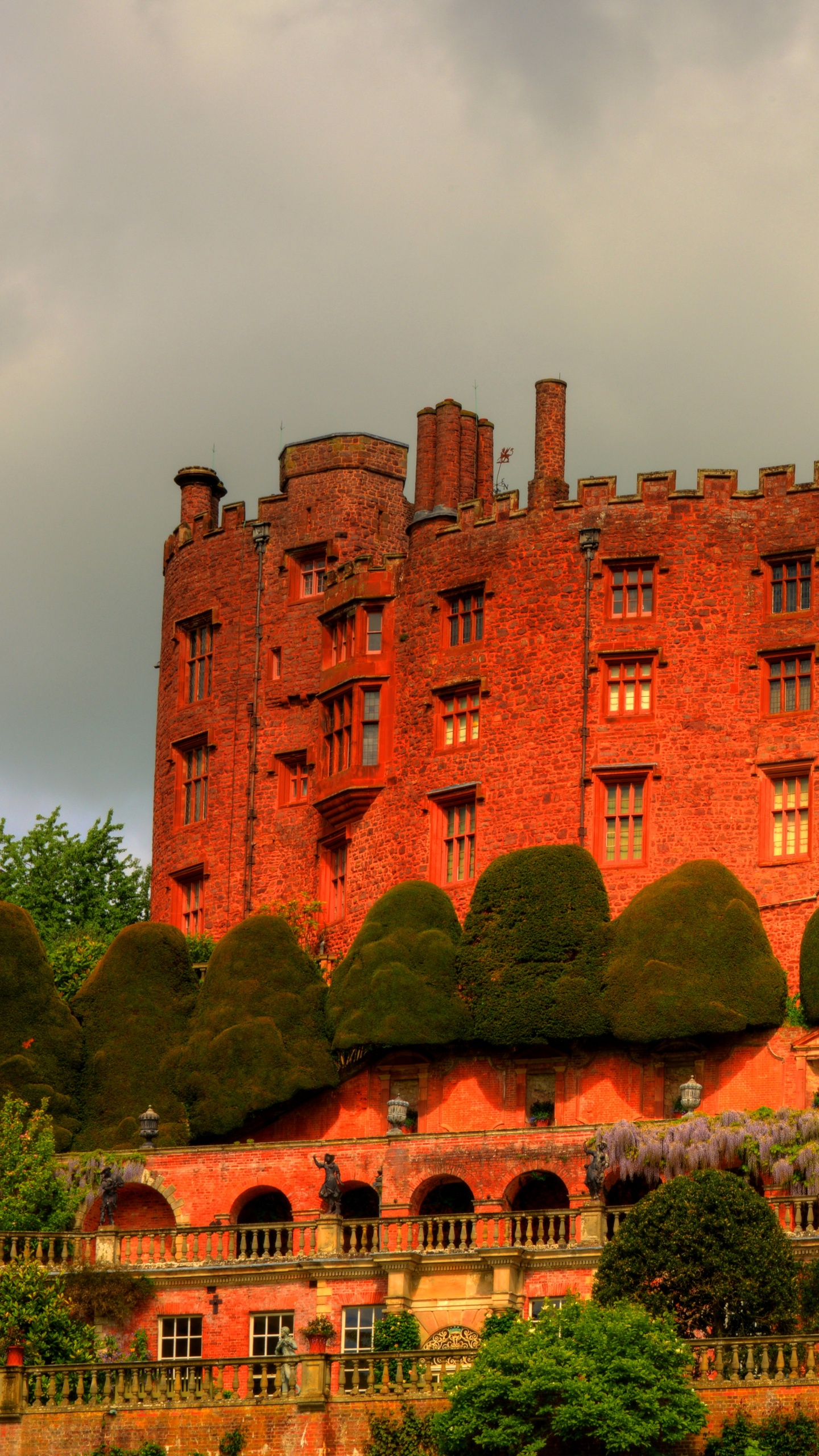 Bâtiment en Béton Brun Près D'arbres Verts Sous Des Nuages Blancs Pendant la Journée. Wallpaper in 1440x2560 Resolution