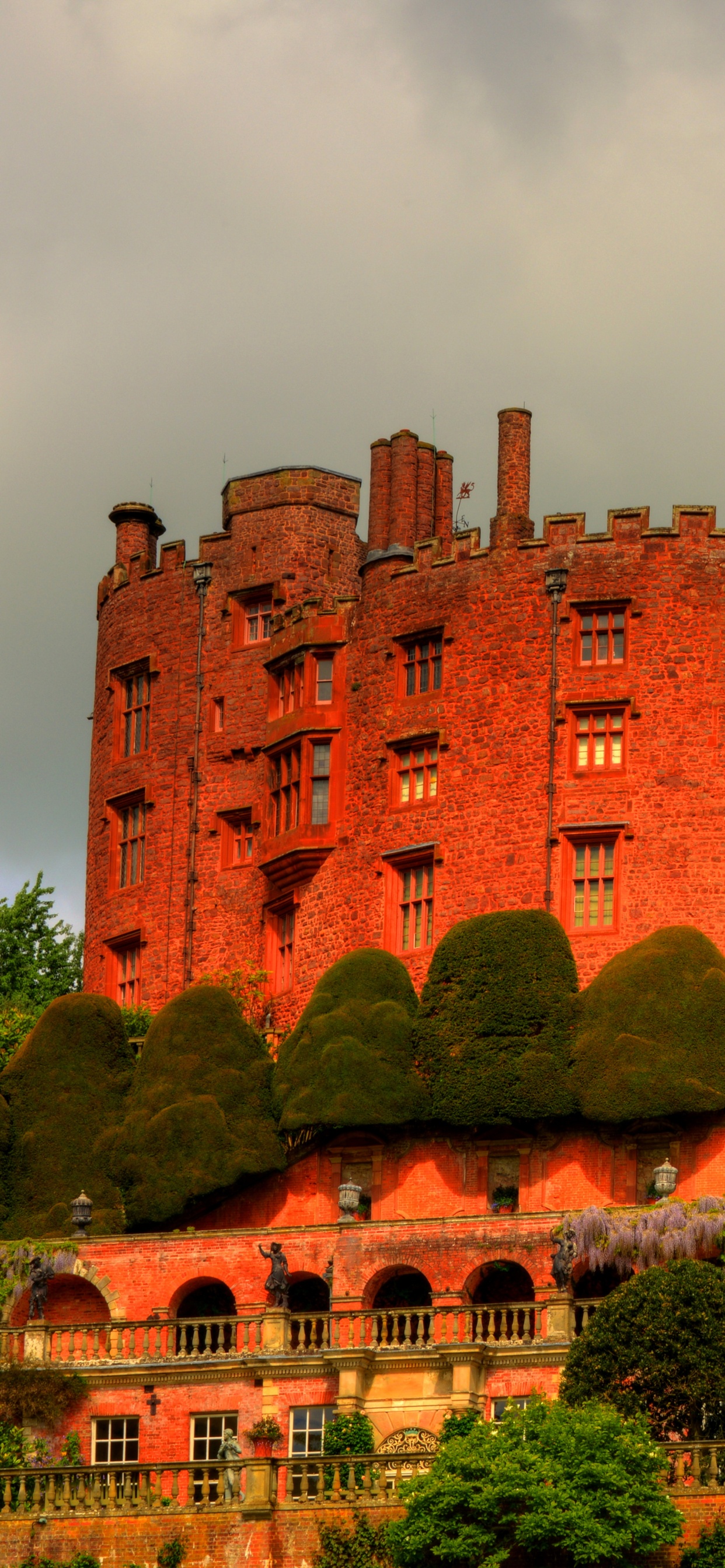 Braunes Betongebäude in Der Nähe Von Grünen Bäumen Unter Weißen Wolken Tagsüber. Wallpaper in 1242x2688 Resolution